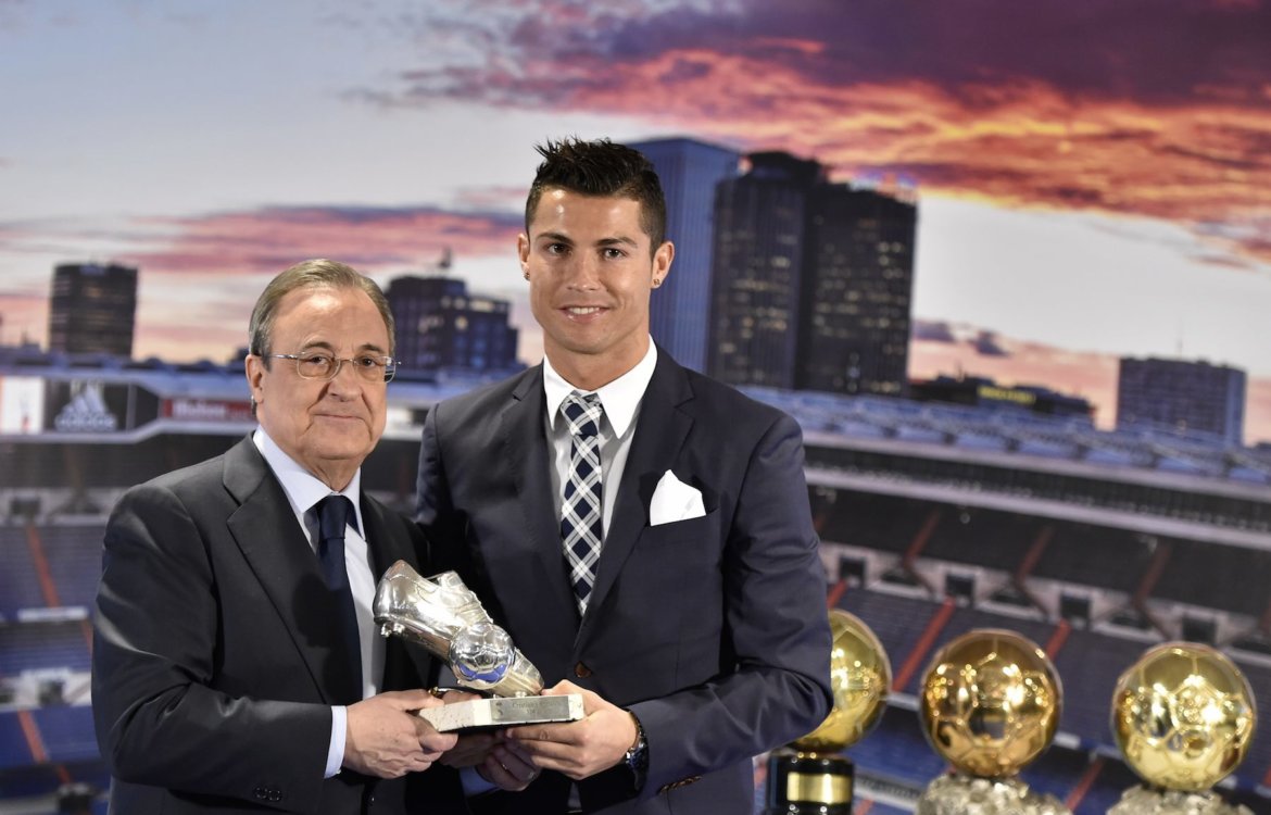 Real Madrid's forward Portuguese Cristiano Ronaldo (R) receives a trophy fom his club's president Florentino Perez after becoming Real Madrid's all-time leading scorer at the Santiago Bernabeu